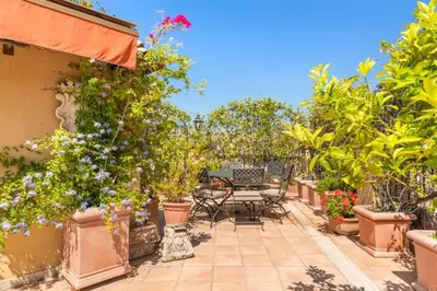 a patio with plants and a table and chairs at Casa Colonna, a Burghesius home in Rome