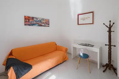 an orange bed in a white room with a desk at Luminoso vicino Piazzale Flaminio e Roma centro in Rome