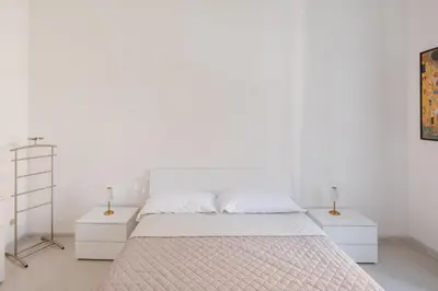a bedroom with white walls and a bed with two night stands at Luminoso vicino Piazzale Flaminio e Roma centro in Rome