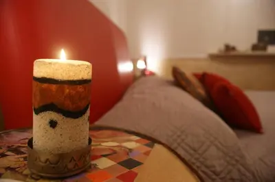 a candle sitting on a table next to a bed at Aldebaran in Rome
