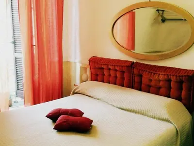 a red teddy bear on a bed with a mirror at Aldebaran in Rome