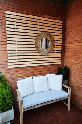a bench sitting on a wall with a mirror and a wreath at Vatican luxury - private parking free - meospiti luxury in Rome