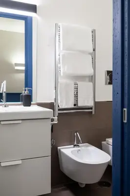a bathroom with a sink and a toilet and towels at Maison Ammiragli Vatican Rooms in Rome
