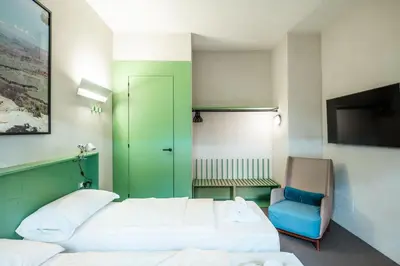 a hotel room with two beds and a chair at Maison Ammiragli Vatican Rooms in Rome