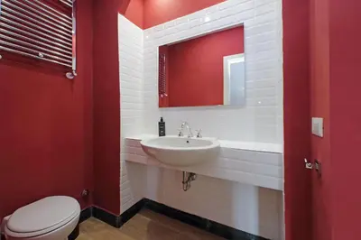 a red bathroom with a sink and a toilet at suity I monkeys apartment in Rome