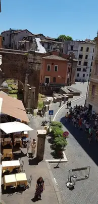 a group of people walking down a city street at Over the Roman ruins in Rome