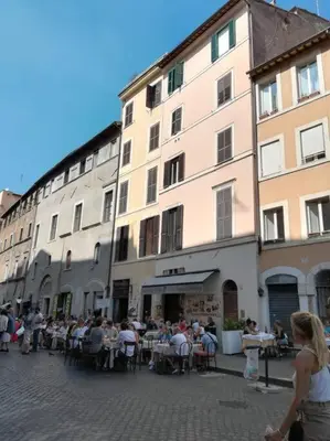 a group of people sitting at tables outside a building at Over the Roman ruins in Rome