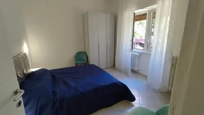 a bedroom with a blue bed and a window at VATICAN GREEN GARDEN in Rome