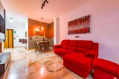 a living room with a red couch and a table at Alle Mura Aurelie Apartment in Rome