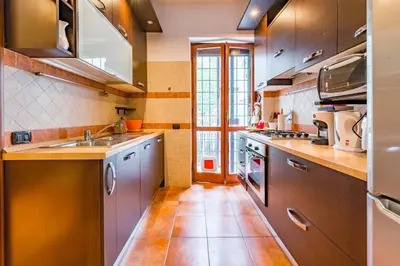 a kitchen with stainless steel appliances and a tile floor at Alle Mura Aurelie Apartment in Rome