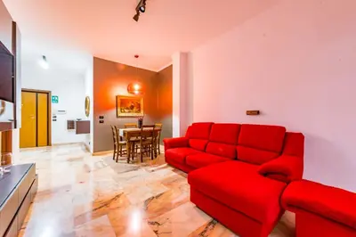 a living room with a red couch and a table at Alle Mura Aurelie Apartment in Rome