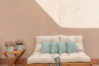a white couch with two blue pillows on it at Barberini Caesar Suites in Rome