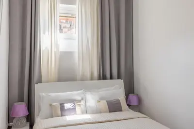 a bedroom with a white bed and a window at Barberini Caesar Suites in Rome