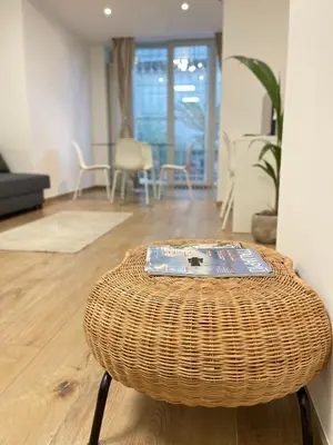 a wicker stool sitting in the middle of a living room at Green Home in Rome