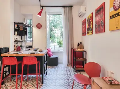 a room with a kitchen with red chairs and a table at Cortile al Vaticano by Bed&Bros in Rome