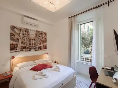 a white bedroom with a bed and a window at Cortile al Vaticano by Bed&Bros in Rome
