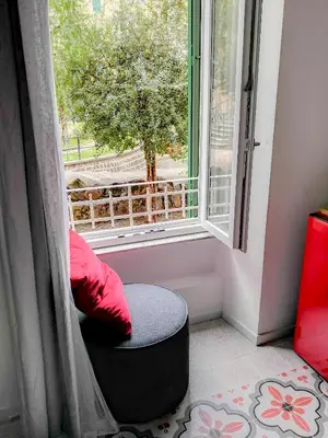 a window with a red pillow and a ottoman in a room at Cortile al Vaticano by Bed&Bros in Rome