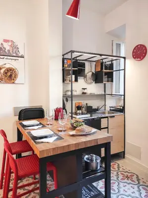 a kitchen with a wooden table and red chairs at Cortile al Vaticano by Bed&Bros in Rome