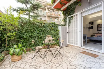 a bedroom with a bed with pink pillows and a painting at Holiday Homes Rome - Portuense 21 - Studio with little private Garden in Rome