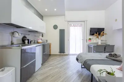 a kitchen and living room with two beds in a room at Holiday Homes Rome - Portuense 21 - Studio with little private Garden in Rome