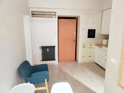 a living room with a blue chair and a door at Il Cortile - Appartamento nel cuore di Testaccio in Rome
