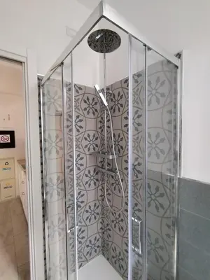 a shower with a glass door in a bathroom at Il Cortile - Appartamento nel cuore di Testaccio in Rome
