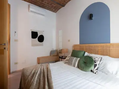 a bedroom with a bed with white sheets and green pillows at The Best Rent - Two-bedroom apartment with terrace near Trevi Fountain in Rome