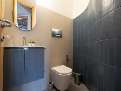 a bathroom with a toilet and a sink and a mirror at The Best Rent - Two-bedroom apartment with terrace near Trevi Fountain in Rome