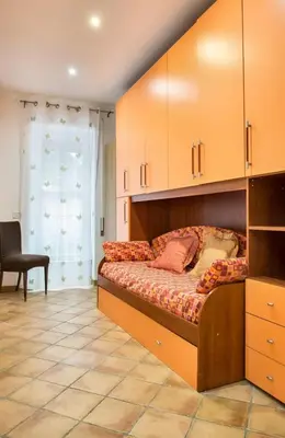 a bedroom with a large bed with wooden cabinets at Appartamento con giardino via silvestri in Rome