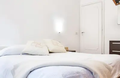 a white bed with two pillows on top of it at Appartamento con giardino via silvestri in Rome