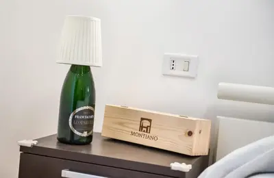a bottle of wine sitting on a table next to a lamp at Appartamento con giardino via silvestri in Rome
