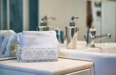 a basket of towels sitting on a bathroom sink at Appartamento con giardino via silvestri in Rome