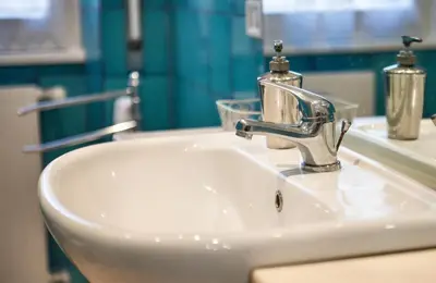 a bathroom sink with a faucet on top of it at Appartamento con giardino via silvestri in Rome