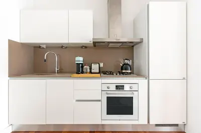 a white kitchen with white cabinets and a stove at 15 Minuti a Piedi dai Musei Vaticani in Rome