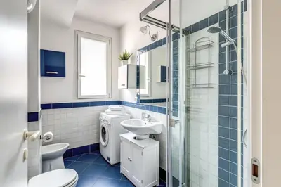 a blue and white bathroom with a toilet and a sink at Rdd in Rome