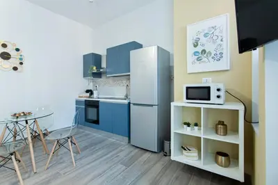 a kitchen with a refrigerator and a table with a microwave at Etta Suite - Close Vatican Museum in Rome