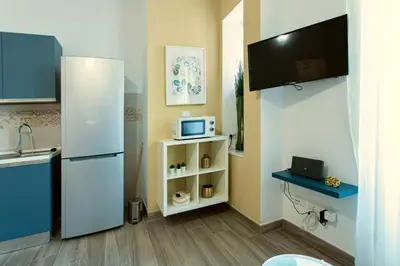 a small kitchen with a refrigerator and a microwave at Etta Suite - Close Vatican Museum in Rome
