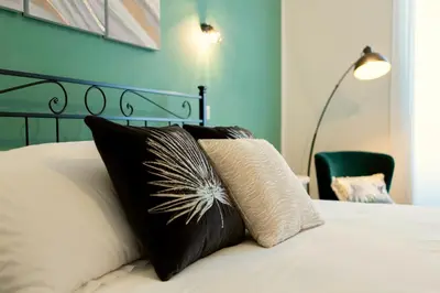 a bed with black and white pillows on it at Etta Suite - Close Vatican Museum in Rome