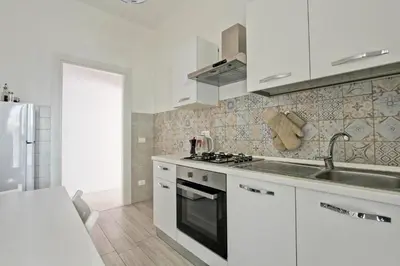 a white kitchen with a sink and a stove at Martina Garden in Rome