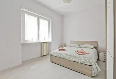 a bedroom with a bed with pink slippers on it at Martina Garden in Rome