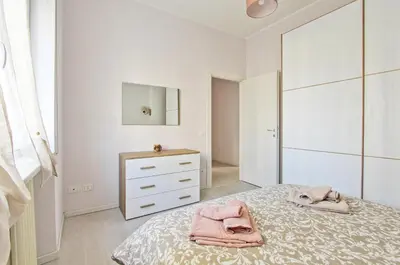 a white bedroom with a bed and a dresser at Martina Garden in Rome