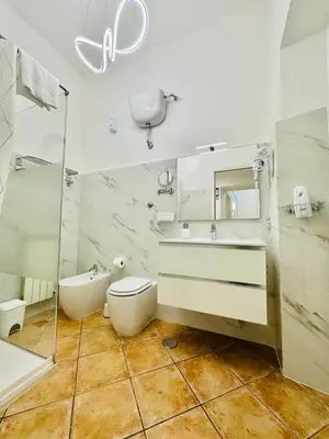 a white bathroom with a toilet and a sink at Casa Vacanza Kambal in Rome