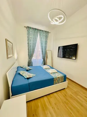 a bedroom with a blue bed and a window at Casa Vacanza Kambal in Rome