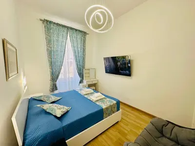a bedroom with a blue bed and a window at Casa Vacanza Kambal in Rome