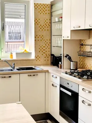 a kitchen with white cabinets and a stove top oven at Baldo Family Apartment - Rome Collection in Rome