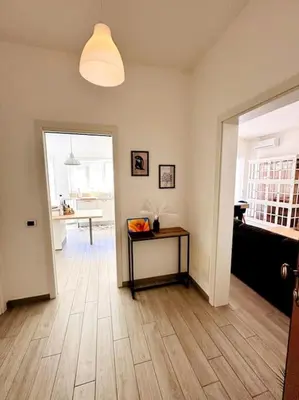 a living room with a table and a hallway with a table at Baldo Family Apartment - Rome Collection in Rome