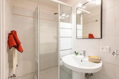 a white bathroom with a sink and a shower at Colosseum Flat - ZEN23 in Rome