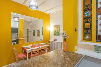 a dining room with yellow walls and a table and chairs at Colosseum Flat - ZEN23 in Rome