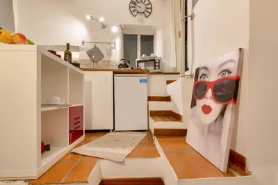 a kitchen with a painting of a woman wearing sunglasses at Dimora Pastini in Rome