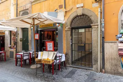 an outdoor restaurant with tables and umbrellas on a street at Dimora Pastini in Rome